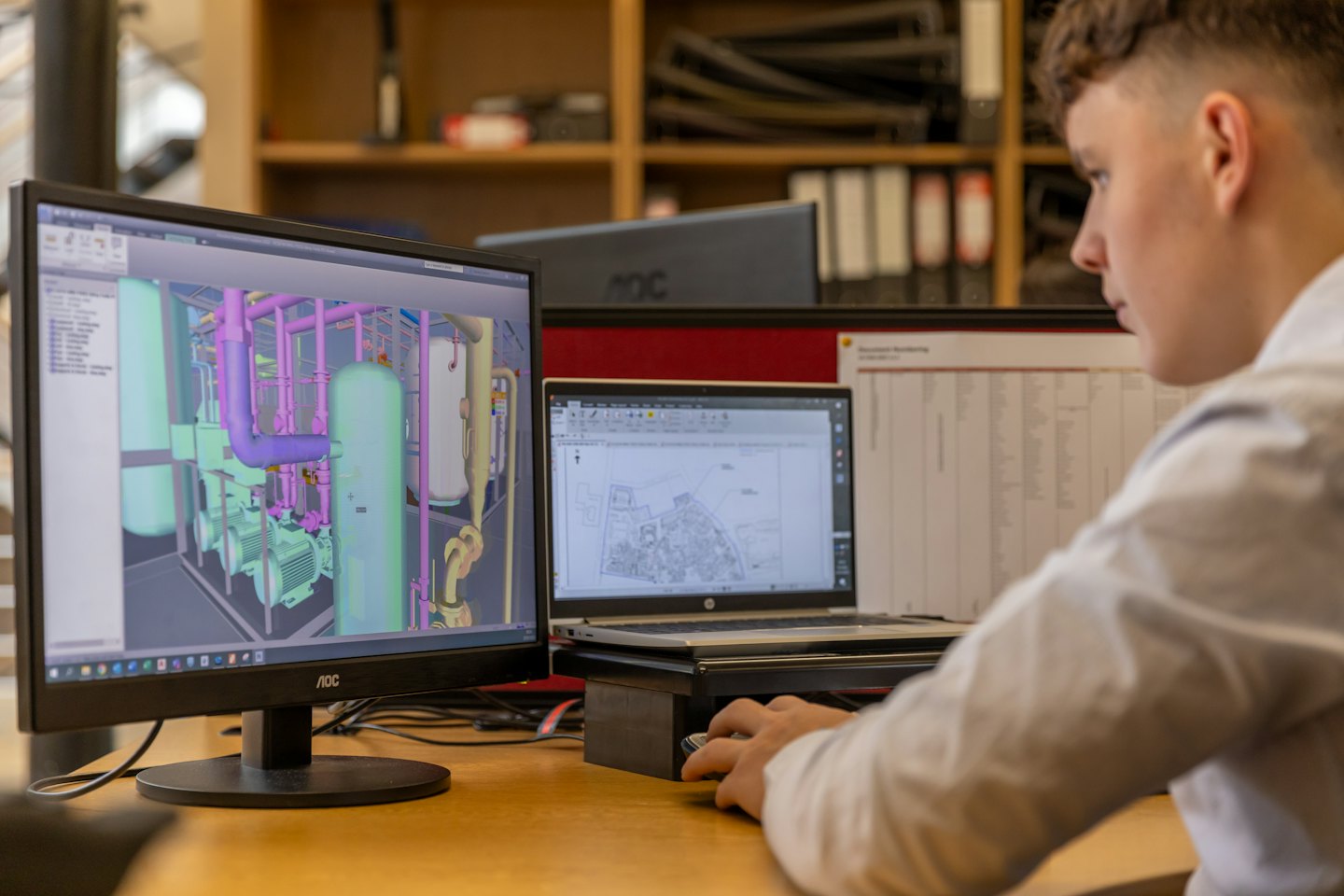 Designer using a computer mouse to work on industrial models.