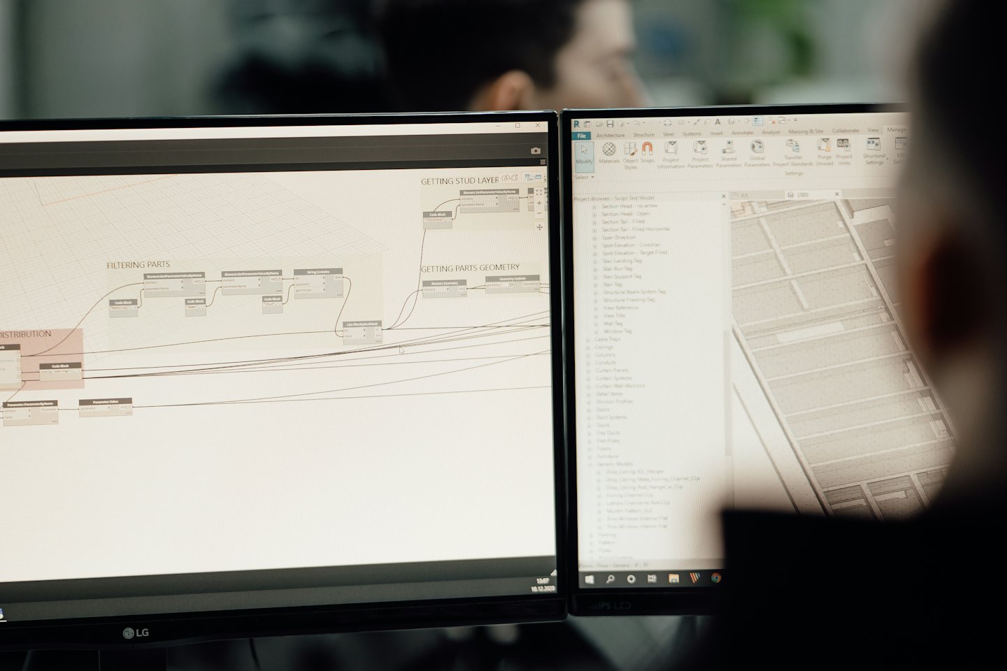 Two computer screens showing architectural software in an office.